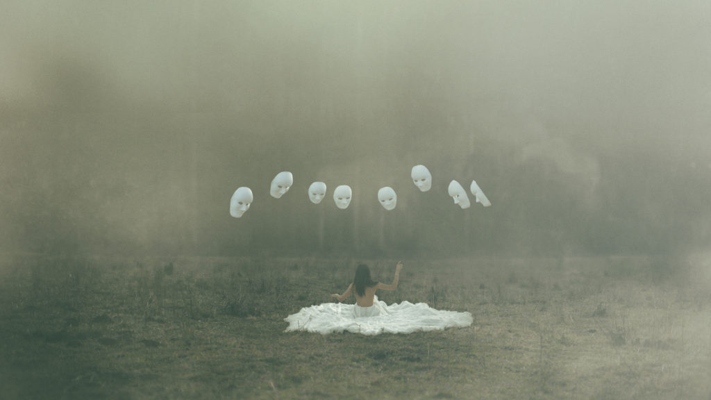 girl in field surrounded by masks